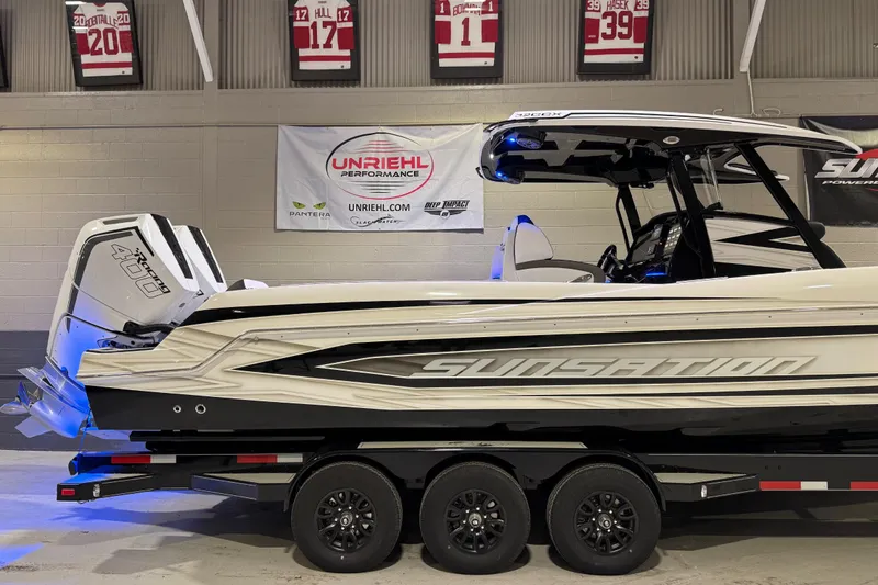 Slide: The Image of 2026 Sunsation 32 CCX boat on trailer, displayed indoors with performance banners. - 5