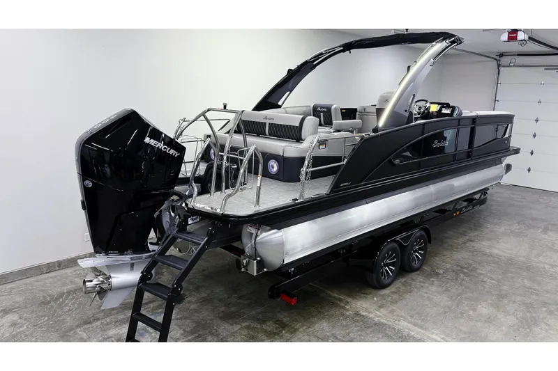 Slide: The Image of 2026 Barletta Lusso 25UA pontoon boat with Mercury engine in a garage setting. - 2