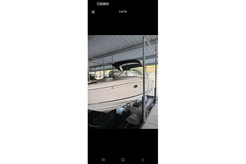 Slide: The Image of 2013 Regal 2700 ES Bowrider on trailer, parked outdoors, clear sky background. - 0