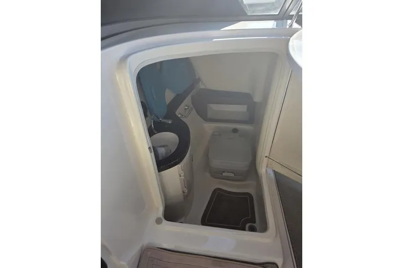 Slide: The Image of Interior of 2013 Regal 2700 ES Bowrider boat, featuring compact bathroom amenities. - 10