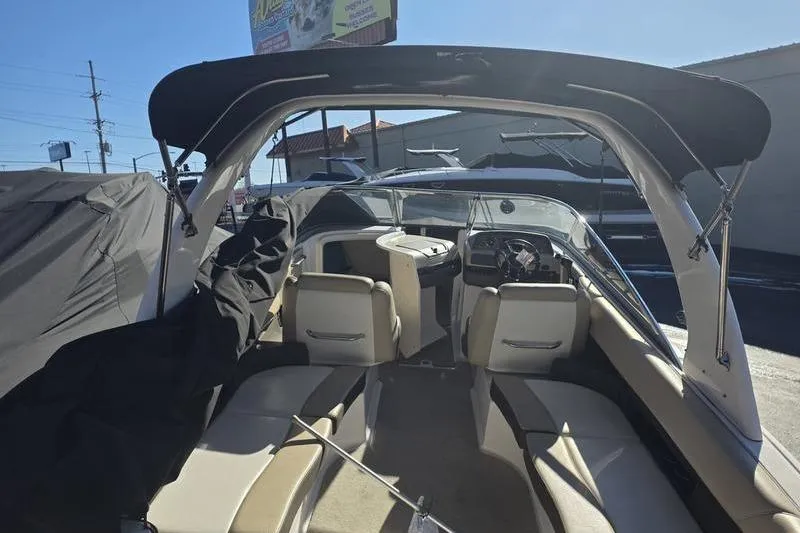 Slide: The Image of 2013 Regal 2700 ES Bowrider interior with seating and dashboard, under a canopy. - 8