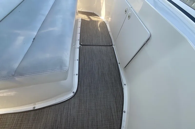 Slide: The Image of 2000 Silverton 392 Motor Yacht interior with cushioned seating and carpeted flooring. - 13