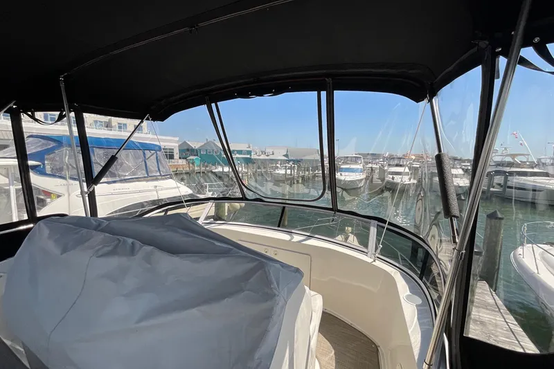 Slide: The Image of 2000 Silverton 392 Motor Yacht interior view at marina, showcasing helm and docked boats. - 18