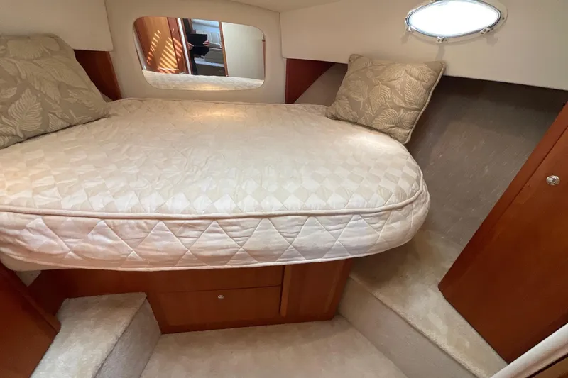Slide: The Image of Cozy cabin interior of 2000 Silverton 392 Motor Yacht with plush bedding and wooden accents. - 28