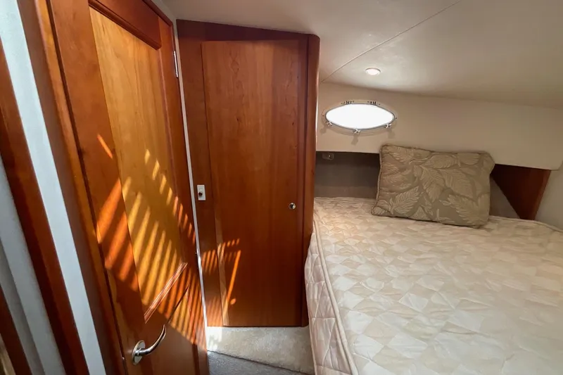 Slide: The Image of Interior cabin of 2000 Silverton 392 Motor Yacht with bed and wooden door. - 29