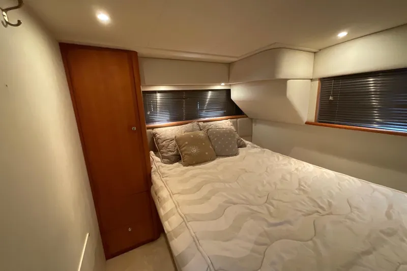 Slide: The Image of Cozy bedroom interior of 2000 Silverton 392 Motor Yacht with plush bedding and wooden accents. - 34