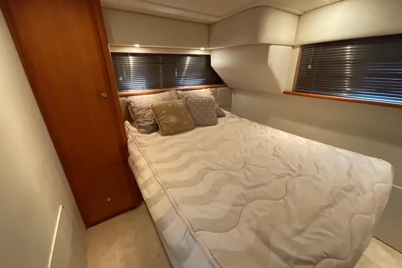 Slide: The Image of Cozy bedroom interior of 2000 Silverton 392 Motor Yacht with plush bedding and wooden accents. - 35