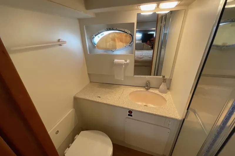 Slide: The Image of Bathroom interior of 2000 Silverton 392 Motor Yacht with sink, toilet, and porthole window. - 37