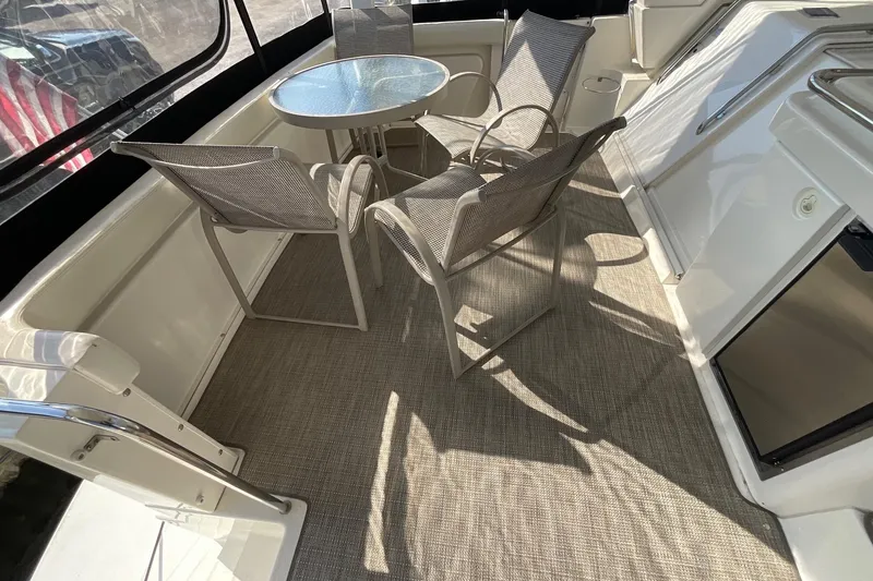 Slide: The Image of 2000 Silverton 392 Motor Yacht deck with table and chairs, featuring modern outdoor seating. - 5