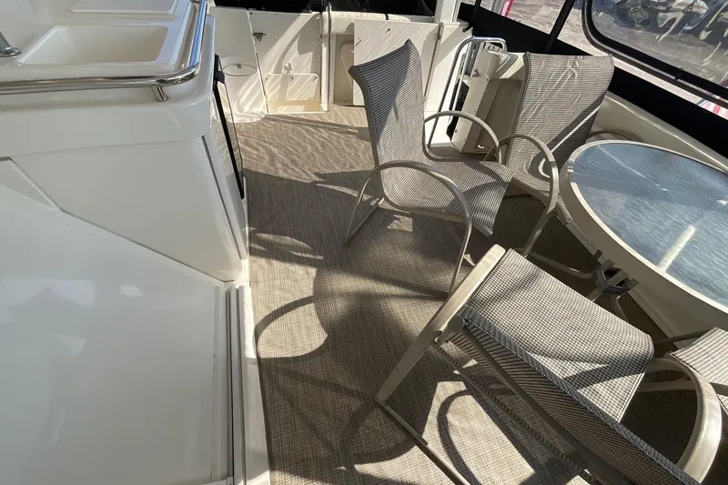 Slide: The Image of 2000 Silverton 392 Motor Yacht interior with chairs and table on deck. - 6