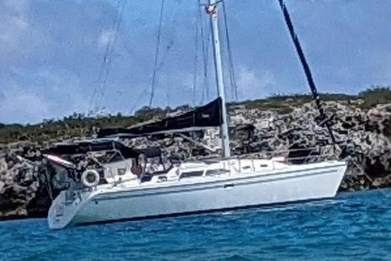 Slide: The Image of Sailboat Catalina 350 MkII 2005 anchored near rocky shoreline under blue sky. - 1