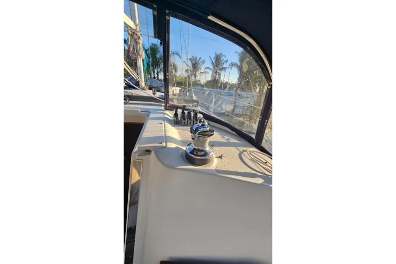 Slide: The Image of 2005 Catalina 350 sailboat cockpit with winch and ropes, docked near palm trees. - 14