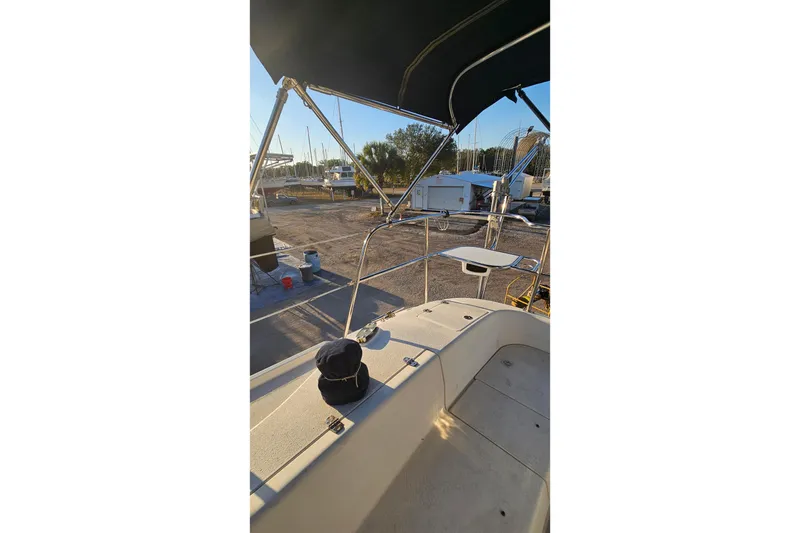 Slide: The Image of 2005 Catalina 350 sailboat deck with canopy, docked in a marina under sunlight. - 19