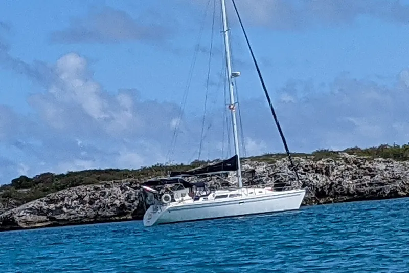 Slide: The Image of Sailboat Catalina 350 MkII 2005 anchored near rocky shoreline under blue sky. - 2