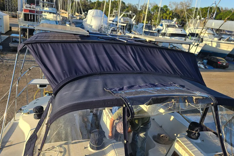 Slide: The Image of Catalina 350 sailboat, 2005 model, with navy blue canopy in a marina setting. - 21