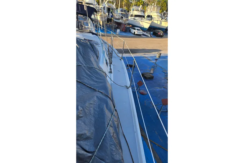 Slide: The Image of Catalina 350 sailboat, 2005 model, docked with covered deck, surrounded by other boats. - 26