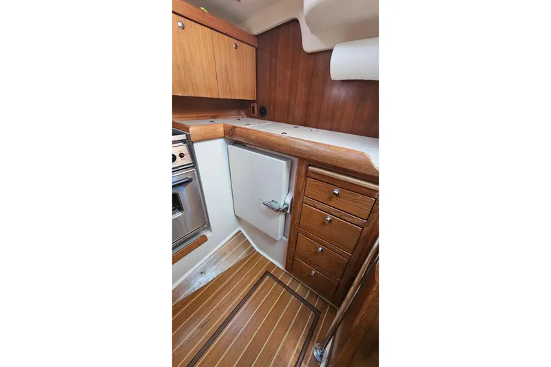Slide: The Image of 2005 Catalina 350 yacht interior galley with wooden cabinetry and flooring. - 31