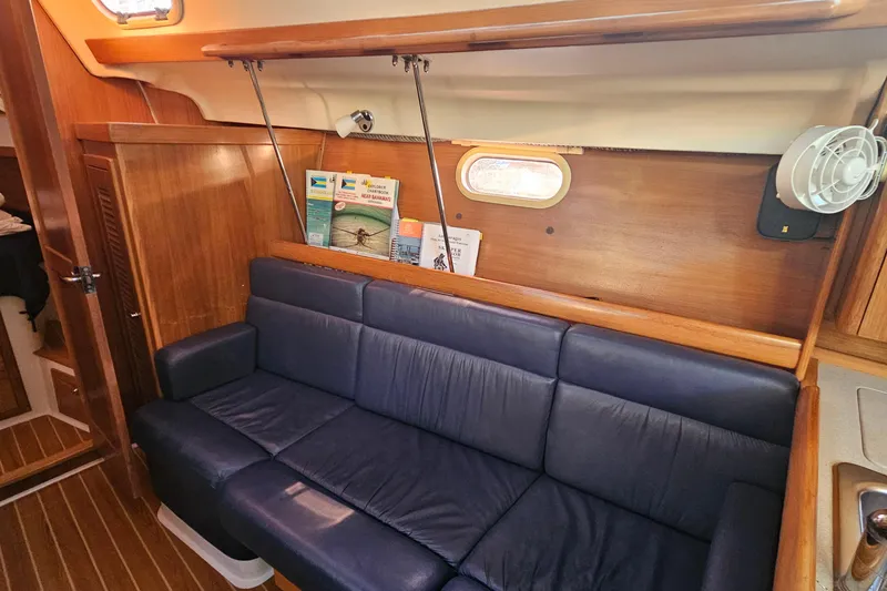 Slide: The Image of Interior of 2005 Catalina 350 sailboat with blue leather sofa and wooden paneling. - 35