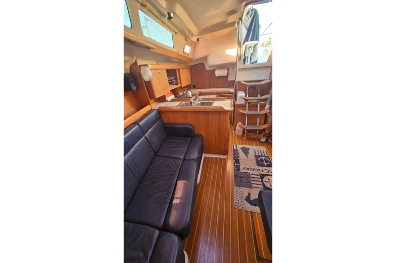 Slide: The Image of Interior of 2005 Catalina 350 sailboat with cozy seating and wooden cabinetry. - 36