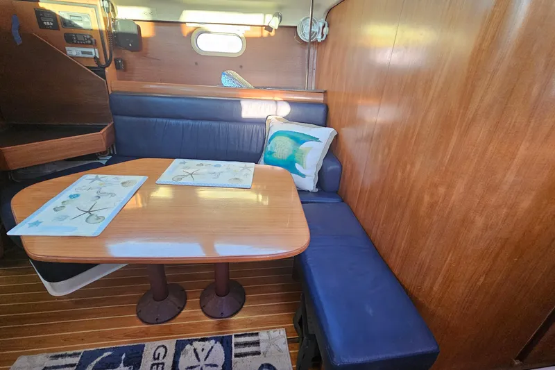 Slide: The Image of Interior of a 2005 Catalina 350 sailboat with a cozy dining area and nautical decor. - 37