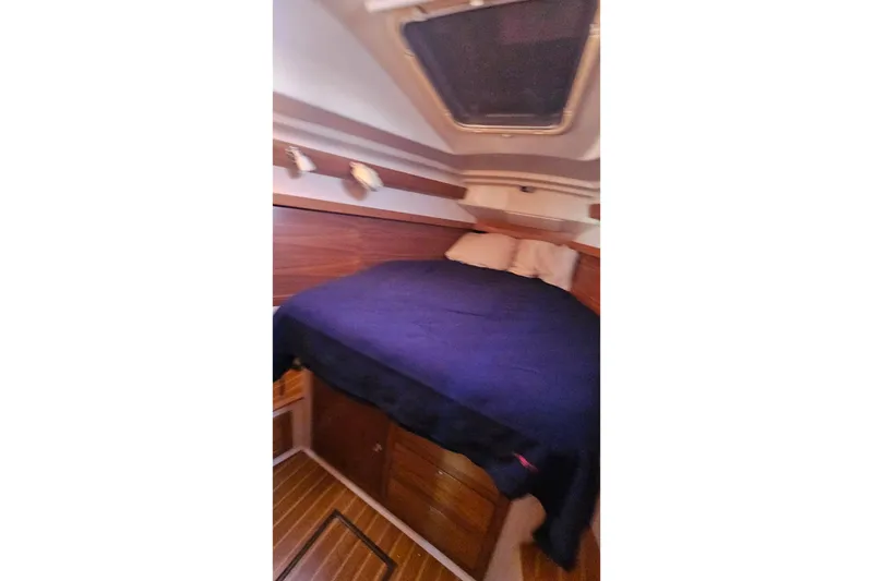 Slide: The Image of Cozy cabin interior of 2005 Catalina 350 sailboat with wooden accents and bedding. - 39