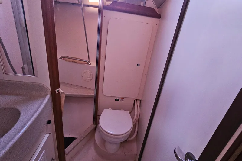 Slide: The Image of Compact bathroom interior of a 2005 Catalina 350 sailboat, featuring a toilet and sink. - 44
