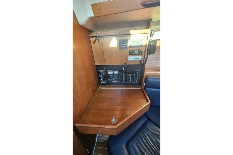 Slide: The Image of Navigation station of a 2005 Catalina 350 sailboat with control panels and seating. - 47