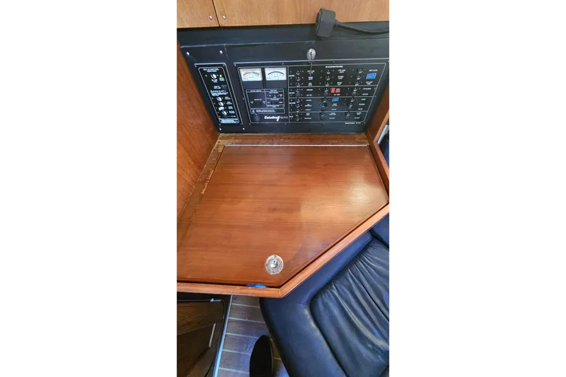 Slide: The Image of Control panel and wooden desk inside a 2005 Catalina 350 yacht cabin. - 48