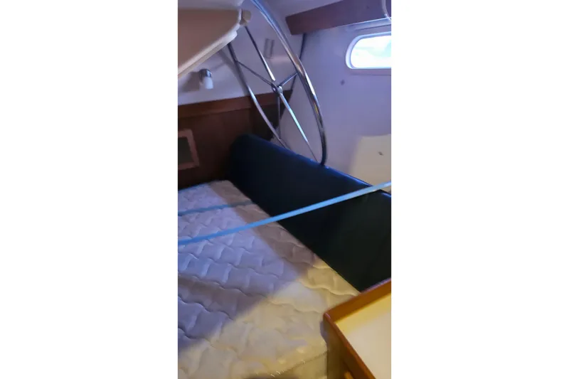 Slide: The Image of Interior cabin of a 2005 Catalina 350 sailboat with mattress and porthole. - 53