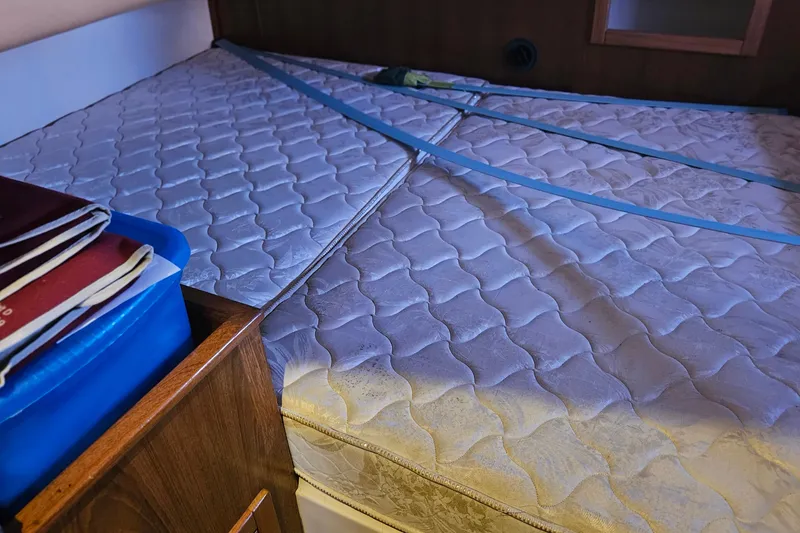 Slide: The Image of Interior of a 2005 Catalina 350 boat showing a mattress with blue straps. - 57
