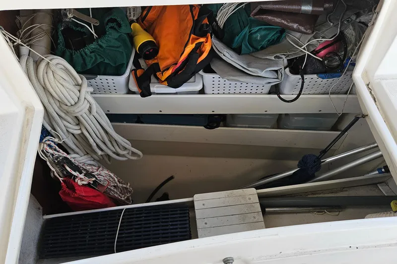 Slide: The Image of Storage compartment on a 2005 Catalina 350 sailboat, filled with ropes and gear. - 58