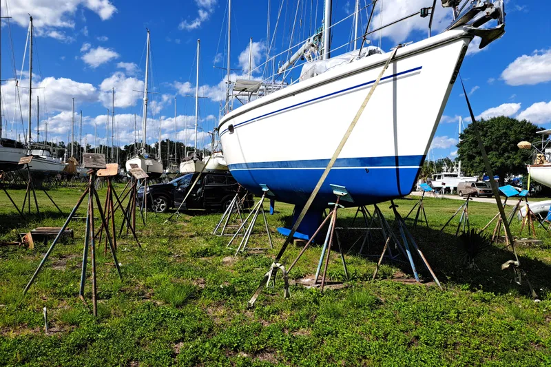 Slide: The Image of 2005 Catalina 350 MkII sailboat on stands in a boatyard under a blue sky. - 7