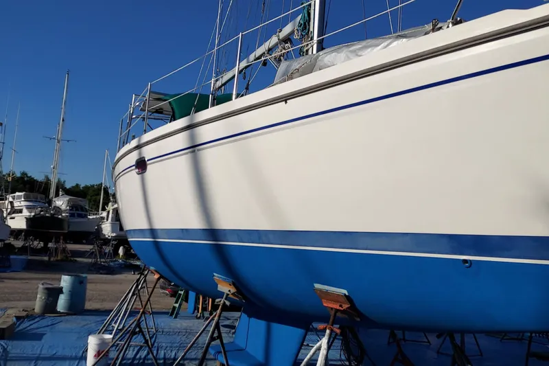 Slide: The Image of 2005 Catalina 350 MkII sailboat on stands, with blue and white hull, in a boatyard. - 71