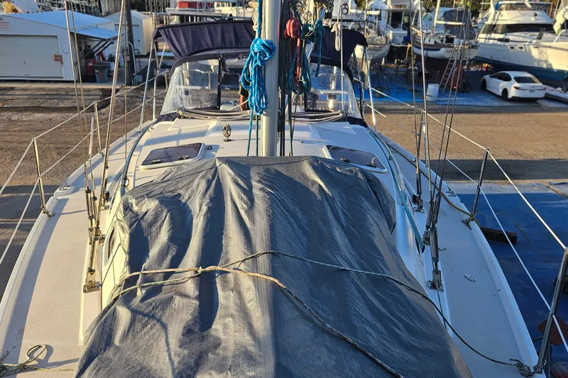Slide: The Image of Catalina 350 sailboat from 2005 docked, covered with tarp, surrounded by other boats. - 72