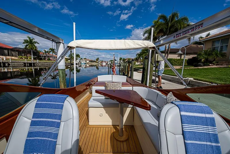 Slide: The Image of 2004 Hinckley Talaria 29 R cabin interior with wood paneling and cushioned seating. - 10