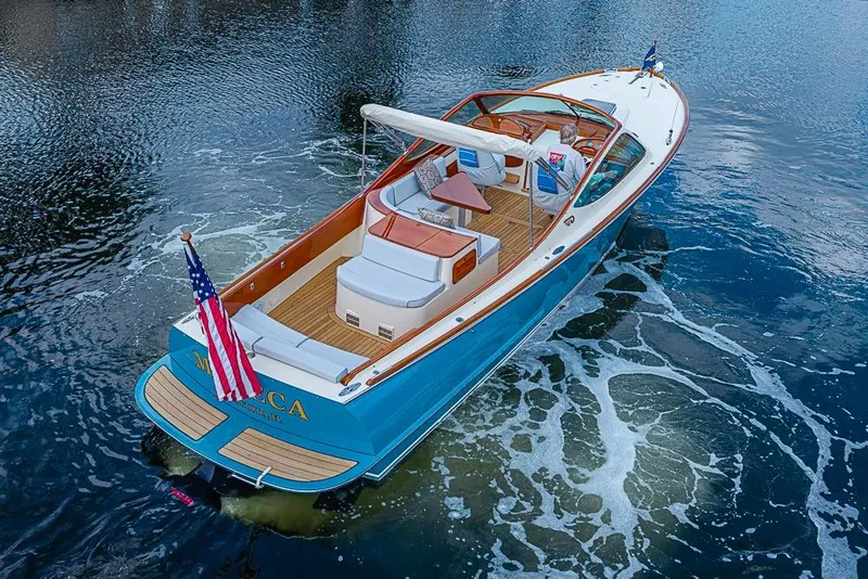 Slide: The Image of 2004 Hinckley Talaria 29 R boat cruising on water, featuring elegant design and American flag. - 18