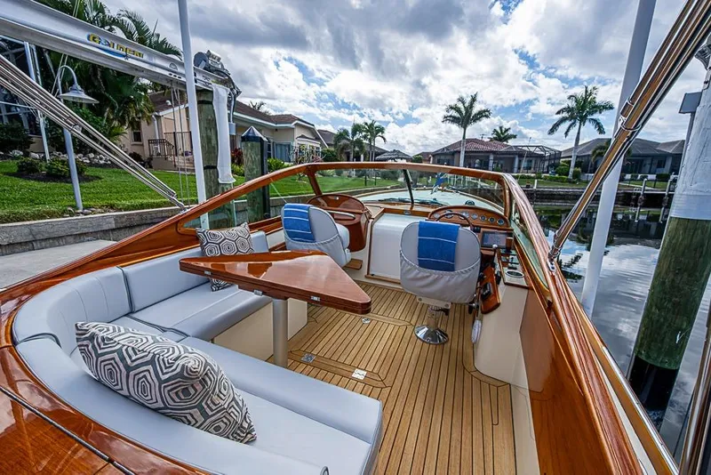 Slide: The Image of 2004 Hinckley Talaria 29 R boat with elegant wooden interior docked by waterfront homes. - 4