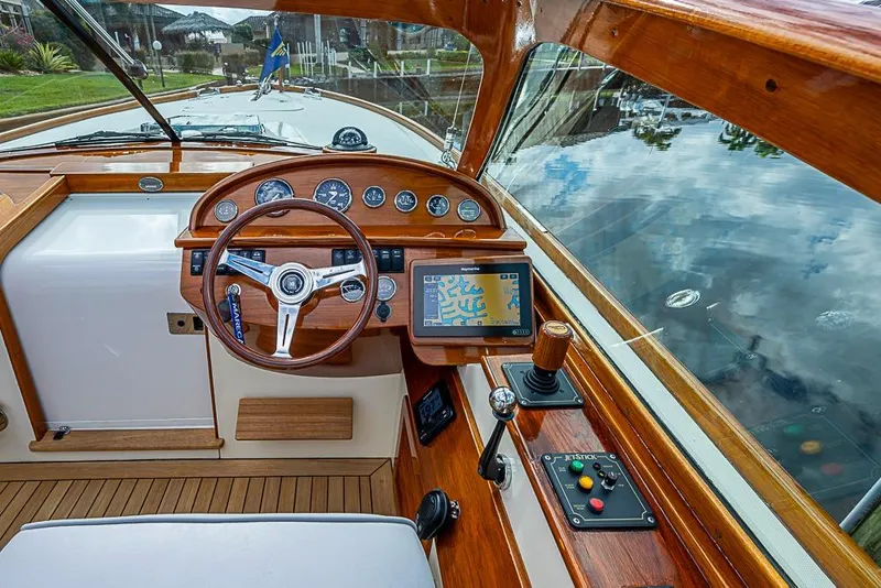 Slide: The Image of 2004 Hinckley Talaria 29 R boat interior with wooden accents and cushioned seating. - 8