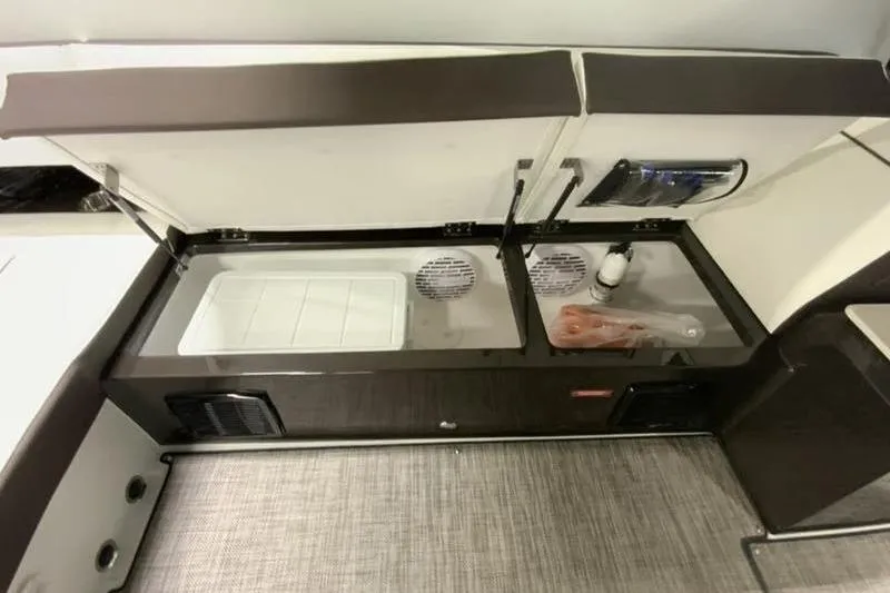 Slide: The Image of 2022 Cobalt A36BR boat interior storage compartment with open lids and visible contents. - 12