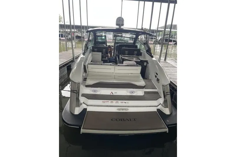 Slide: The Image of 2022 Cobalt A36BR boat docked, rear view showcasing spacious seating and sleek design. - 5