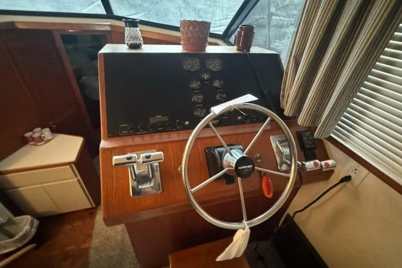 Slide: The Image of 1992 Carver 38 Aft Cabin Motor Yacht helm with steering wheel and control panel. - 10