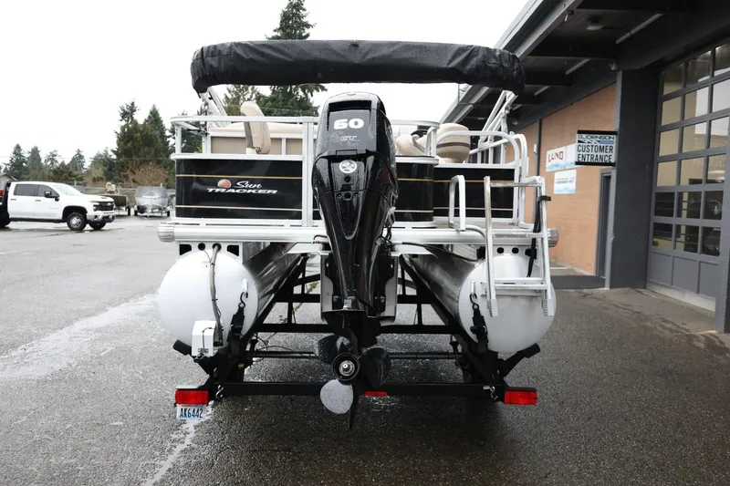 Slide: The Image of 2022 Sun Tracker Bass Buggy 18 DLX pontoon boat with outboard motor, parked outside dealership. - 7