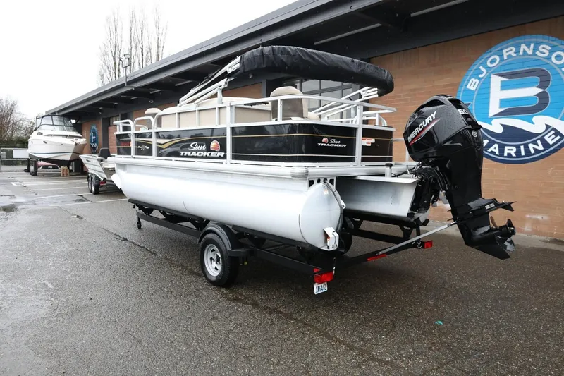 Slide: The Image of 2022 Sun Tracker Bass Buggy 18 DLX pontoon boat with Mercury outboard motor on trailer. - 8