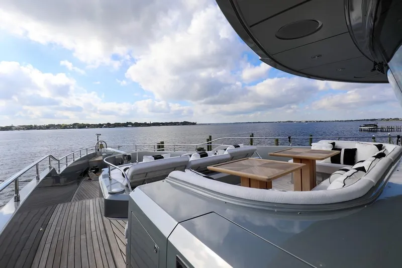Slide: The Image of Luxurious 2025 Majesty 120 yacht deck with seating, overlooking serene waters and cloudy sky. - 10