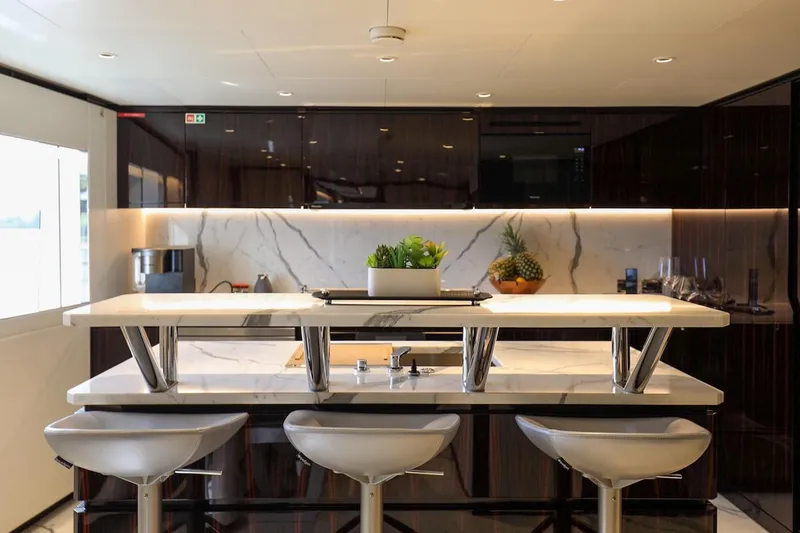 Slide: The Image of Luxurious yacht kitchen with marble countertops, modern stools, and elegant cabinetry, Majesty 120, 2025. - 30