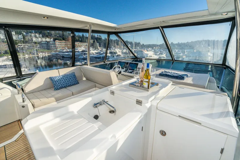 Slide: The Image of Luxurious 2018 Prestige 630 yacht interior with seating, wine, and marina view. - 13