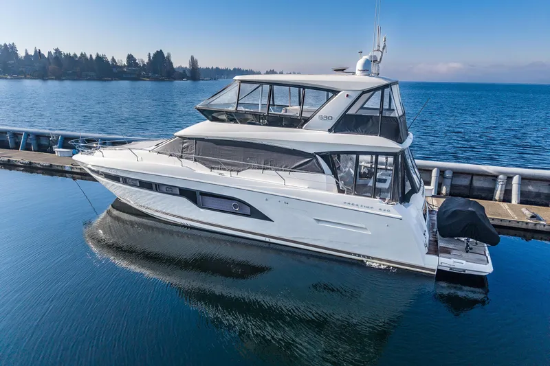 Slide: The Image of 2018 Prestige 630 yacht docked on calm water under clear blue sky. - 2
