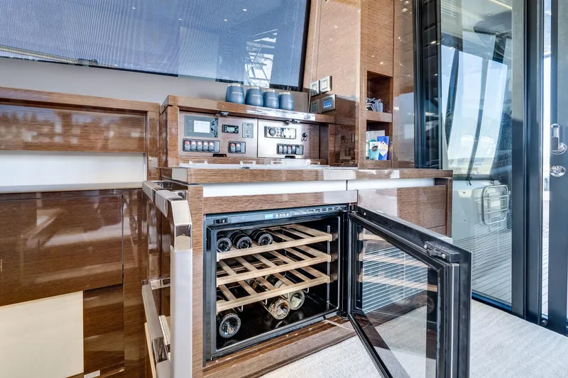 Slide: The Image of Luxurious 2018 Prestige 630 yacht interior with wine cooler and modern wooden cabinetry. - 29