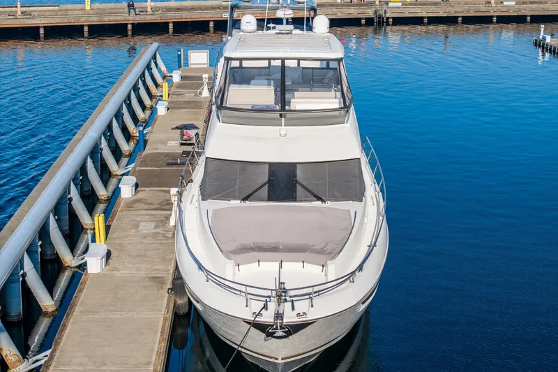 Slide: The Image of Luxury 2018 Prestige 630 yacht docked at marina, calm blue water. - 3