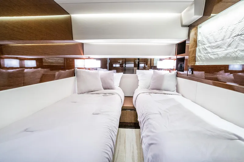 Slide: The Image of Luxurious twin cabin interior of 2018 Prestige 630 yacht, featuring elegant bedding and wood paneling. - 51